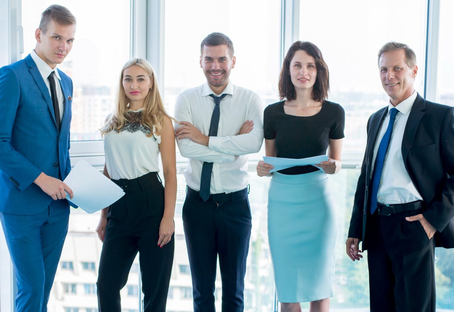 A group of business persons look directly to the camera.